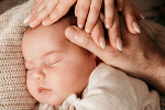Viele Hände auf Babyköpfchen